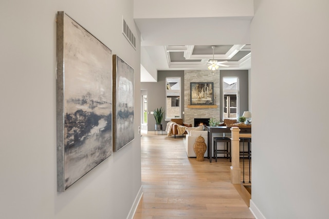 hall featuring coffered ceiling and light hardwood / wood-style flooring