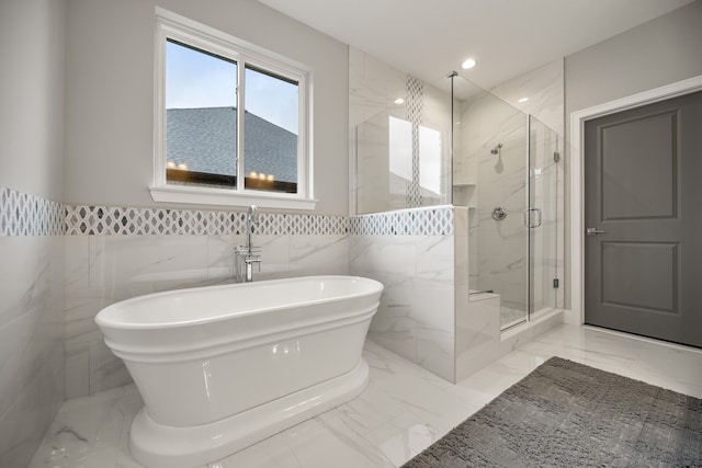 bathroom featuring separate shower and tub and tile walls