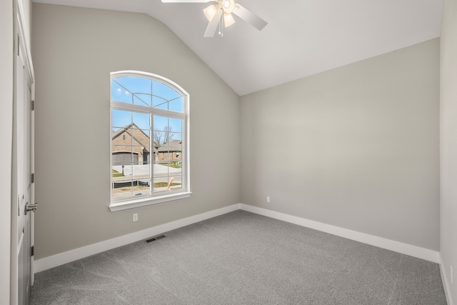 empty room featuring lofted ceiling, ceiling fan, and carpet flooring