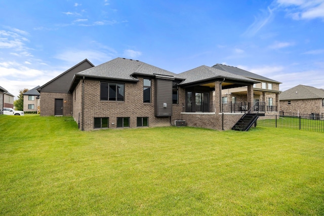 back of property with a lawn and central air condition unit