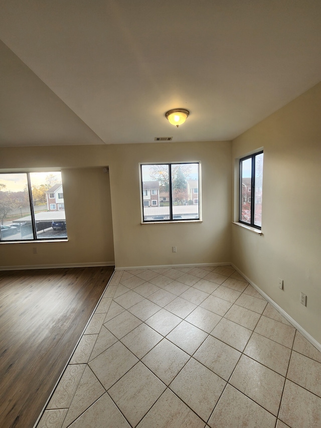 tiled empty room featuring a wealth of natural light