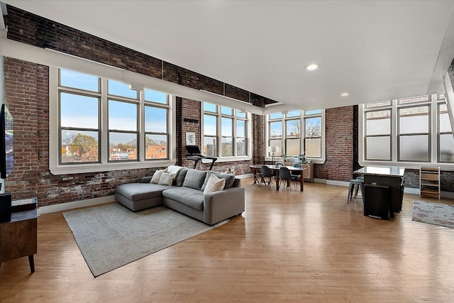 living room with light hardwood / wood-style flooring and brick wall