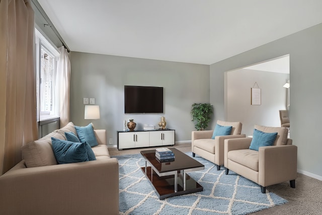 living room featuring carpet and baseboards