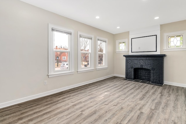 unfurnished living room with a fireplace and light wood-type flooring