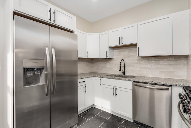 kitchen with white cabinetry, appliances with stainless steel finishes, sink, and light stone counters