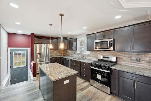 kitchen featuring dark brown cabinetry, decorative light fixtures, stainless steel appliances, and a center island