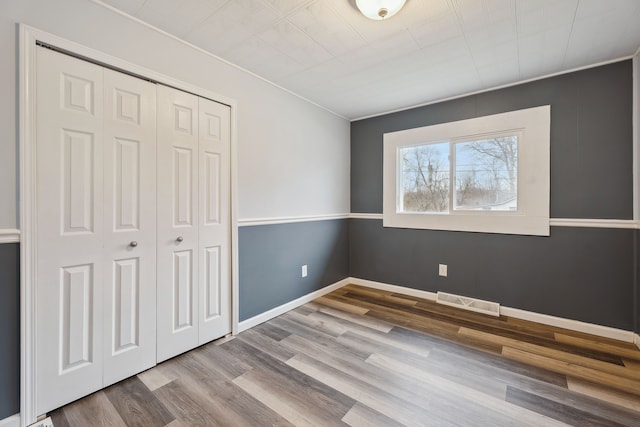 unfurnished bedroom with light wood-type flooring and a closet