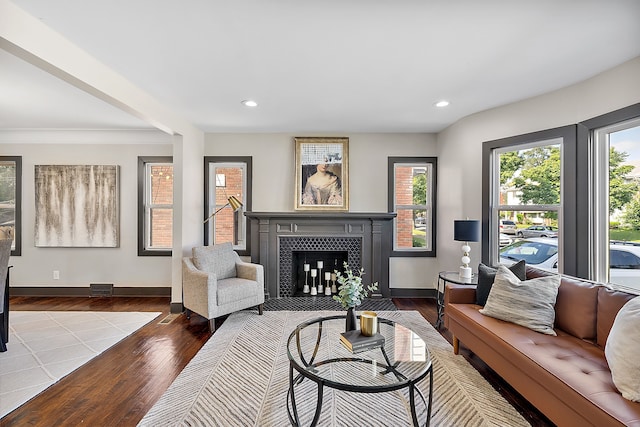 living room featuring a tile fireplace and light wood-type flooring