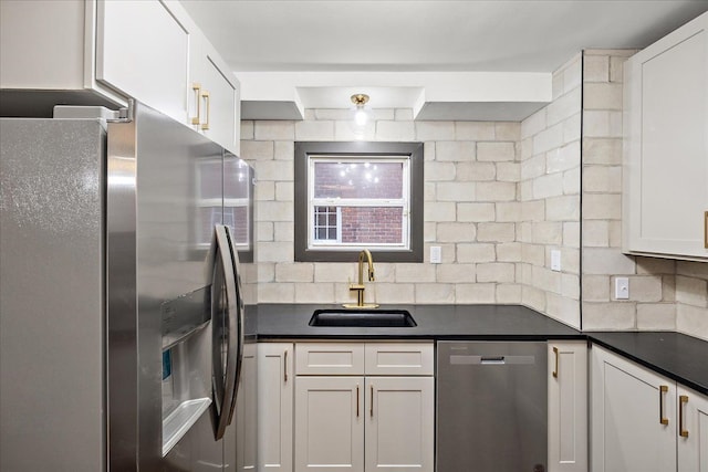 kitchen featuring appliances with stainless steel finishes, sink, white cabinets, and backsplash