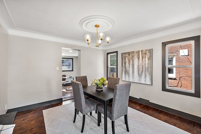 dining room featuring dark hardwood / wood-style flooring, a notable chandelier, and a healthy amount of sunlight