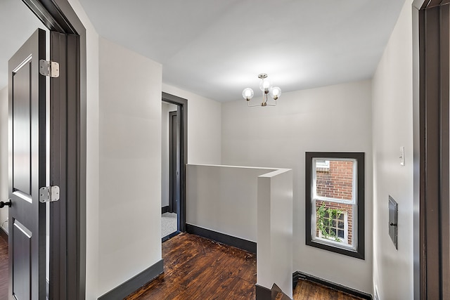 hall featuring dark hardwood / wood-style floors and a notable chandelier