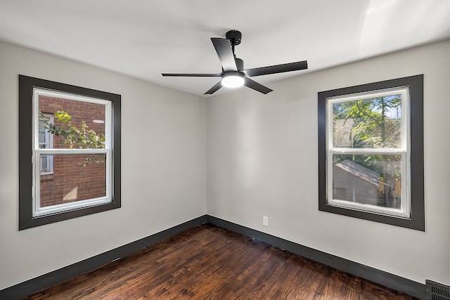 spare room featuring dark wood-type flooring and ceiling fan