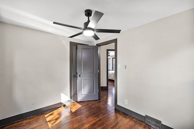 unfurnished bedroom featuring dark hardwood / wood-style floors and ceiling fan