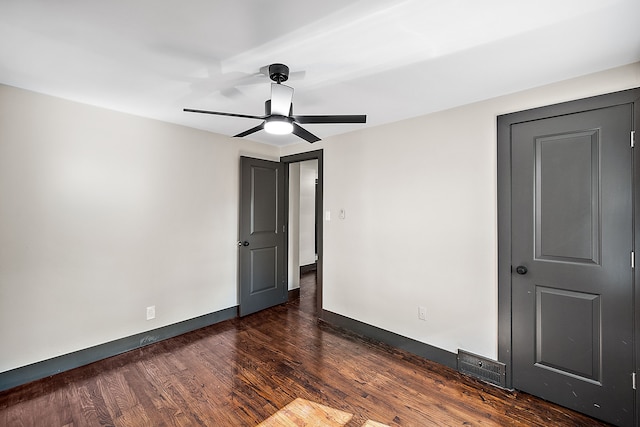 unfurnished bedroom with ceiling fan and dark hardwood / wood-style flooring