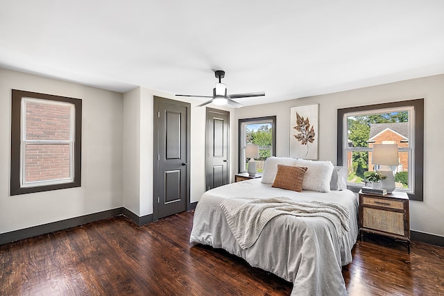 bedroom featuring multiple windows, dark hardwood / wood-style floors, and ceiling fan