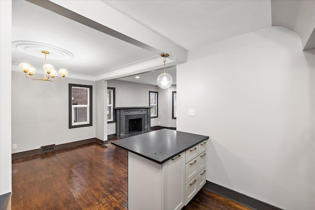 kitchen with white cabinetry, hanging light fixtures, dark wood-type flooring, and a brick fireplace