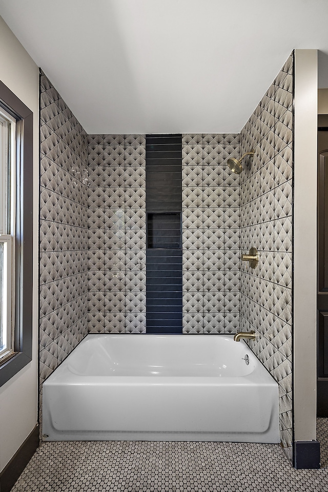 bathroom with a washtub and tile patterned floors