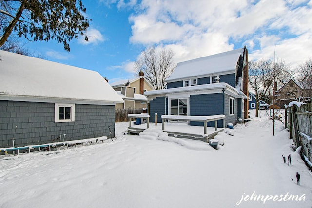 snow covered rear of property featuring a wooden deck