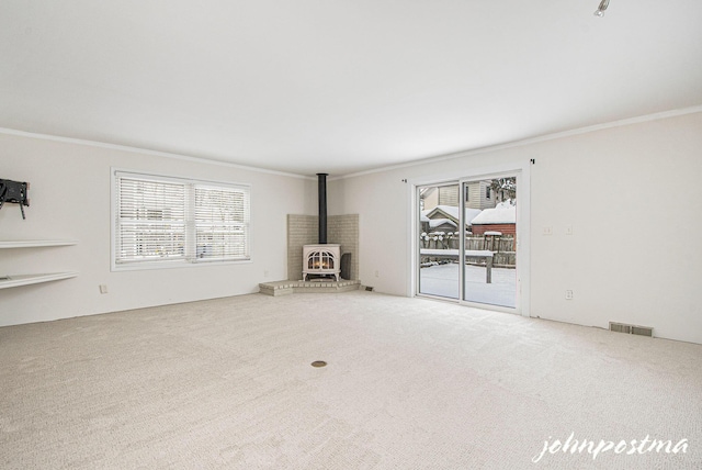 unfurnished living room with ornamental molding, plenty of natural light, and carpet floors