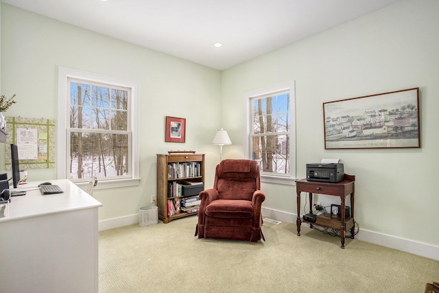 living area featuring a healthy amount of sunlight and light carpet