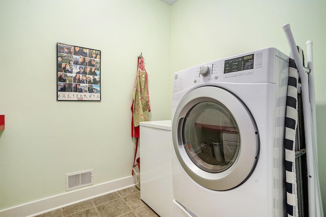 laundry room featuring washer and dryer and light tile patterned floors