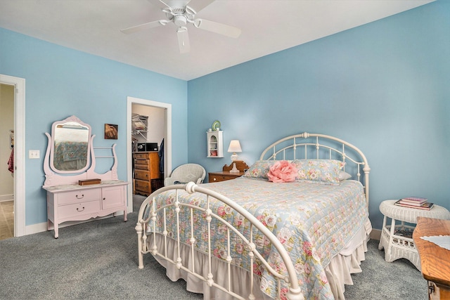 carpeted bedroom with a spacious closet and ceiling fan