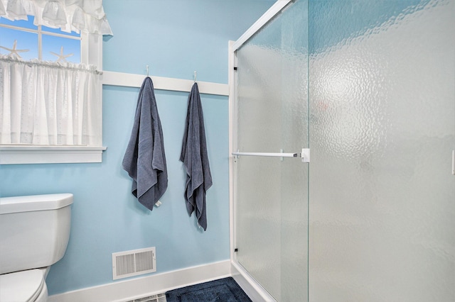 bathroom with toilet and a shower with door