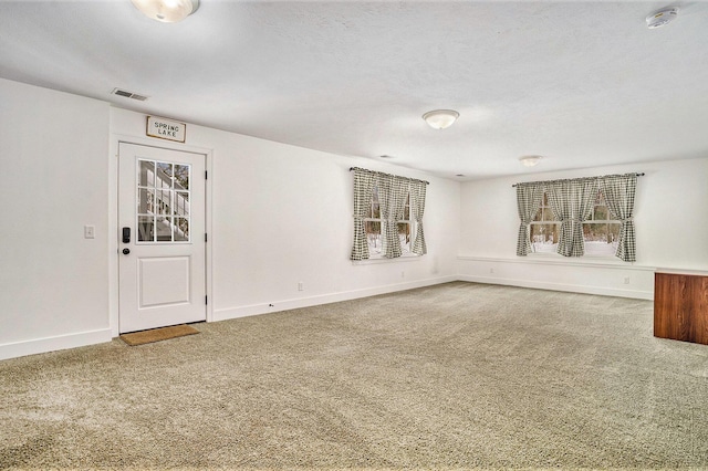 unfurnished room with carpet flooring and a textured ceiling