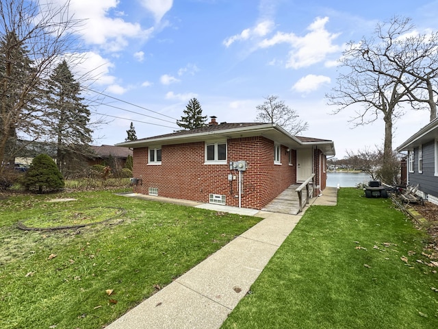 view of side of property with a yard and a water view