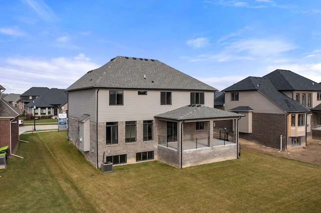 back of house featuring a yard, central AC, and a patio