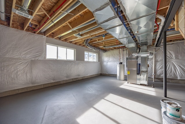 basement with water heater and heating unit