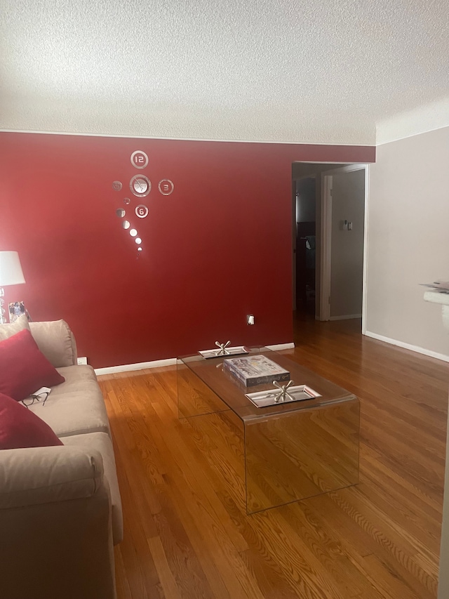 unfurnished living room with hardwood / wood-style flooring and a textured ceiling