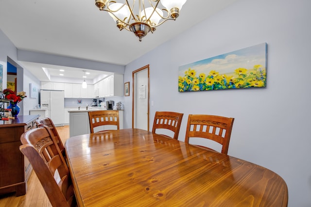 dining room with an inviting chandelier and light hardwood / wood-style flooring