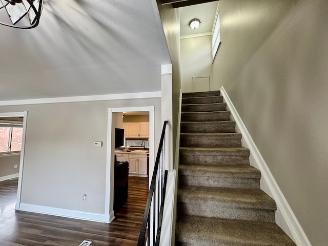 stairs featuring wood-type flooring and sink