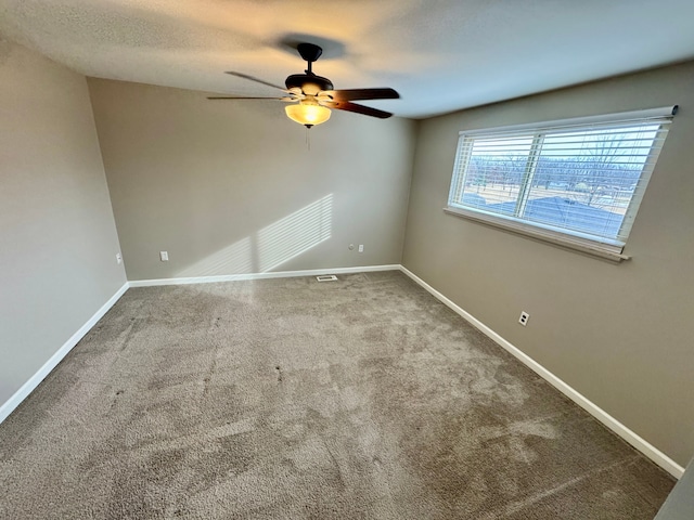 carpeted spare room with a textured ceiling and ceiling fan