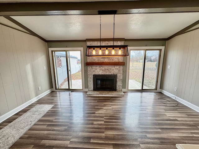 unfurnished living room with dark hardwood / wood-style flooring, a wealth of natural light, lofted ceiling, and a large fireplace