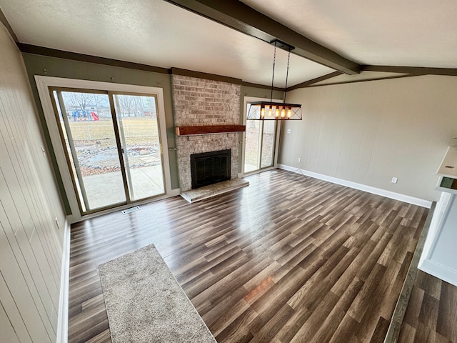 unfurnished living room featuring dark hardwood / wood-style flooring, a fireplace, lofted ceiling with beams, and wooden walls