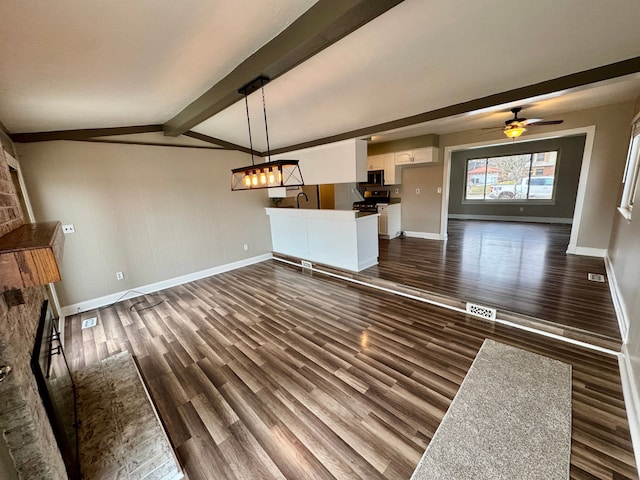 unfurnished living room with ceiling fan, dark hardwood / wood-style floors, and lofted ceiling with beams