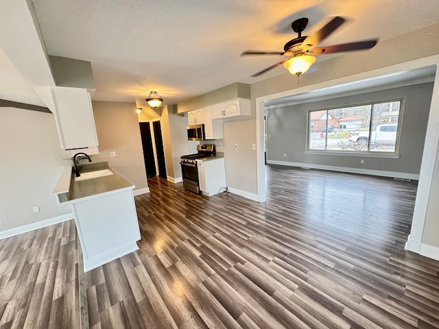 kitchen with stainless steel appliances, dark hardwood / wood-style flooring, sink, and white cabinets