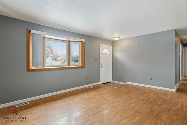 entrance foyer with light hardwood / wood-style floors and a textured ceiling