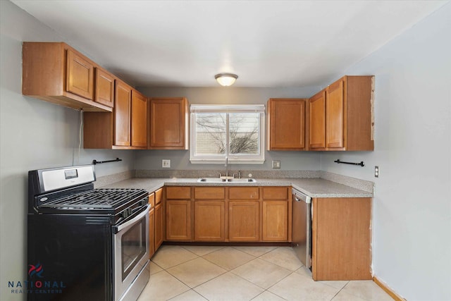 kitchen with stainless steel appliances, sink, and light tile patterned floors