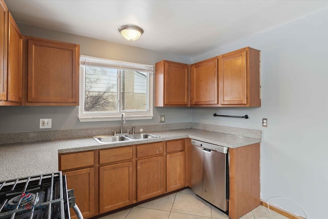 kitchen featuring gas range, dishwasher, sink, and light tile patterned floors