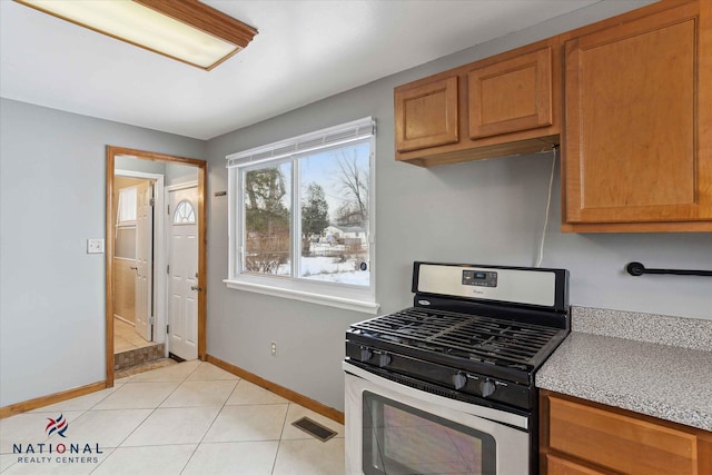 kitchen featuring light tile patterned floors and gas range