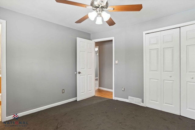 unfurnished bedroom featuring dark carpet, a closet, and ceiling fan