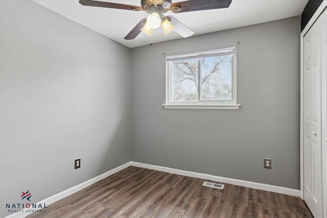 unfurnished bedroom with ceiling fan, dark hardwood / wood-style flooring, and a closet