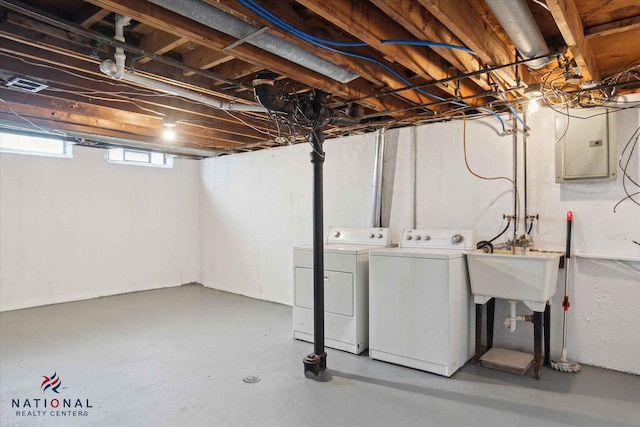 basement featuring electric panel, separate washer and dryer, and sink