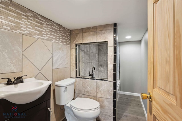 bathroom with vanity, wood-type flooring, toilet, and tile walls