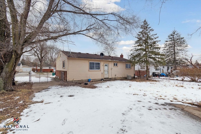 snow covered house with a garage and central air condition unit