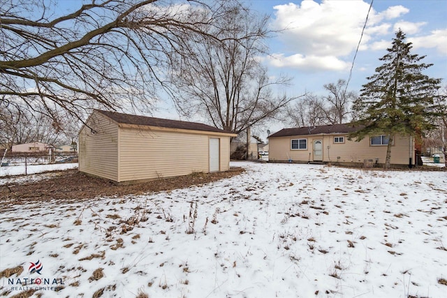 yard covered in snow featuring an outbuilding