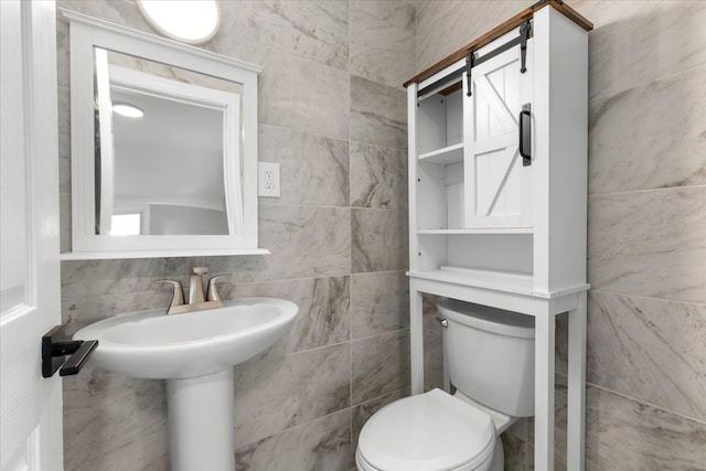 bathroom with tile walls and toilet